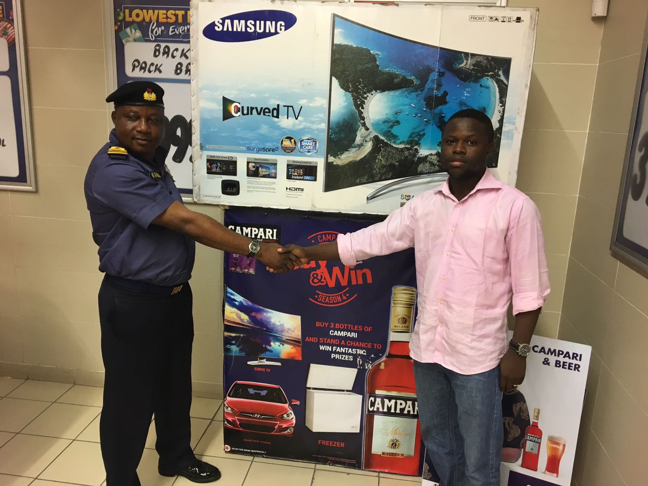 R-L: Brand Manager, Olawande Alaran presenting a brand new Curved LED TV to second prize winner of the Campari Buy N Win Promo, Olu Jacob